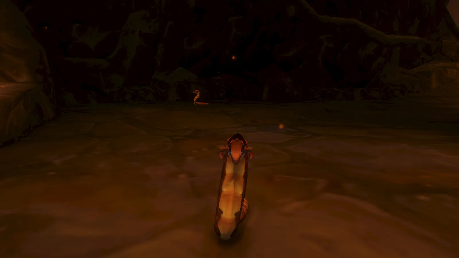 A close view of an Earthborer worm facing the camera in the dark, lava-lit cave of Ragefire Chasm
